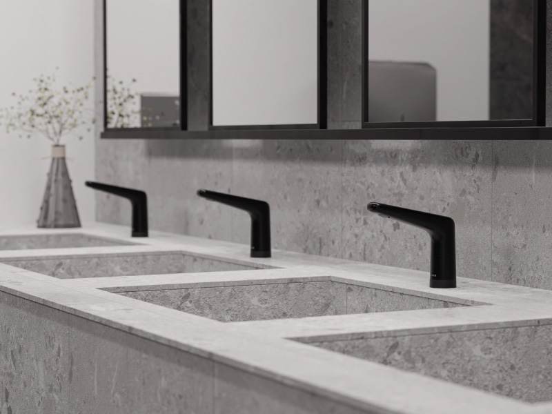 Baño comercial con grifería negra