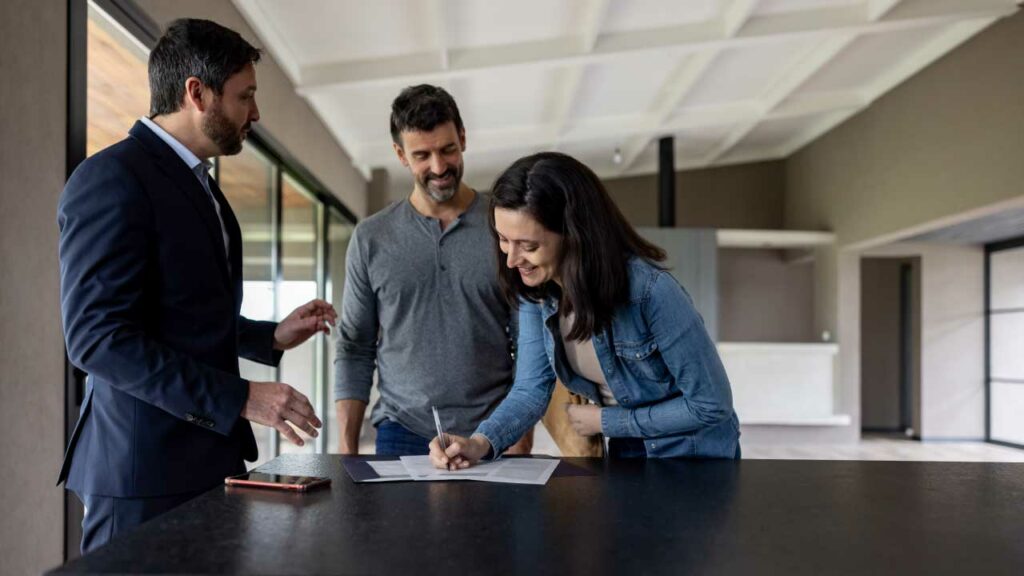 Pareja firmando documentos legales de su apartamento