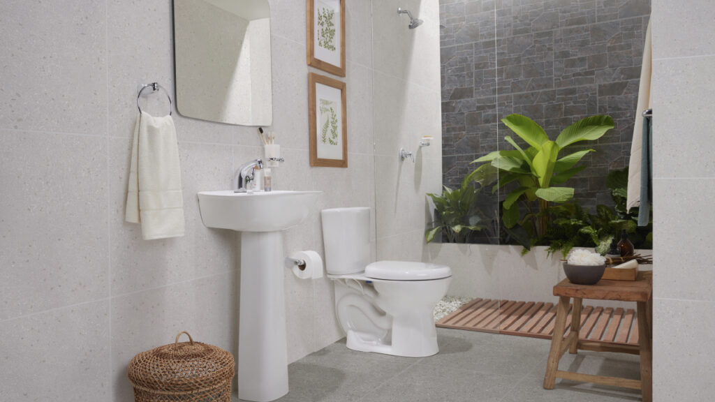 Ambiente baño Corona con grifería, sanitario y lavamanos Aluvia, Pared Chantarela Oxido y piso Cantera Duropiso gris.