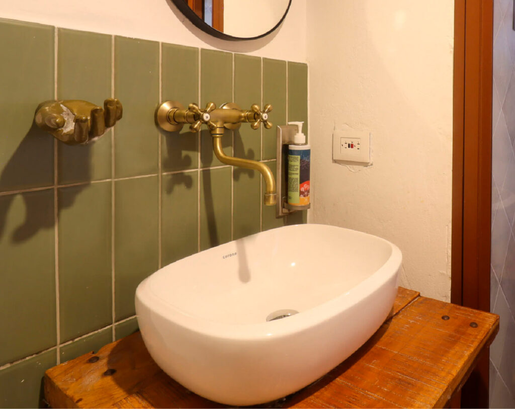 Ambiente baño con brick personalizado color verde oliva y lavamanos Cascade.